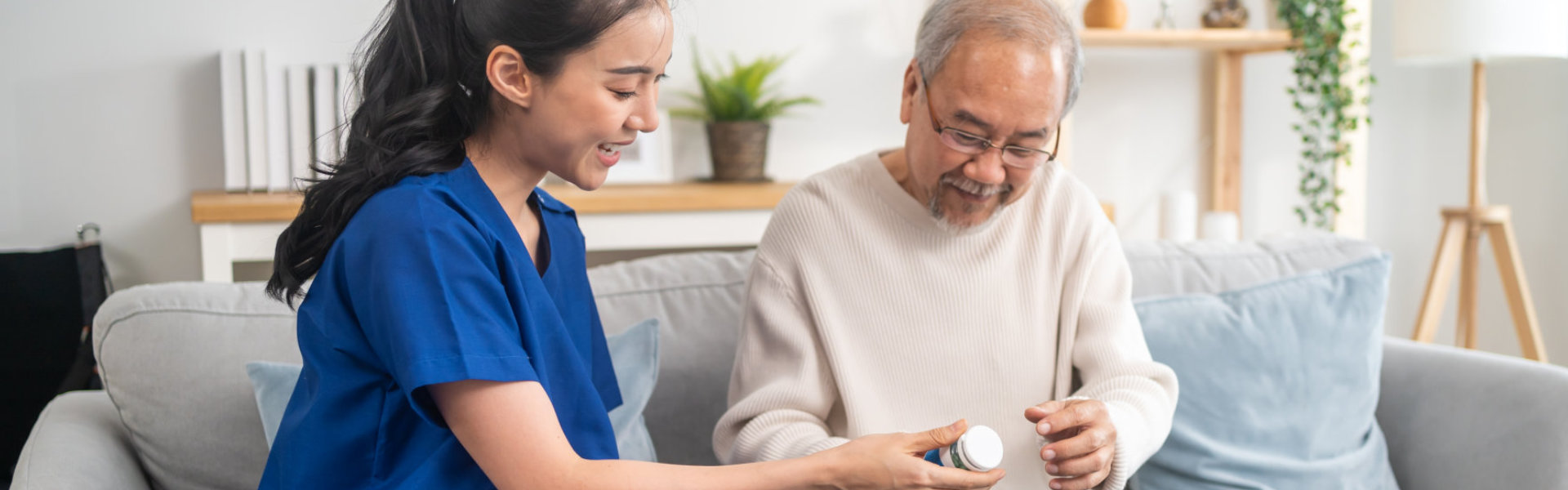 caregiver gives medicine to the elderly man