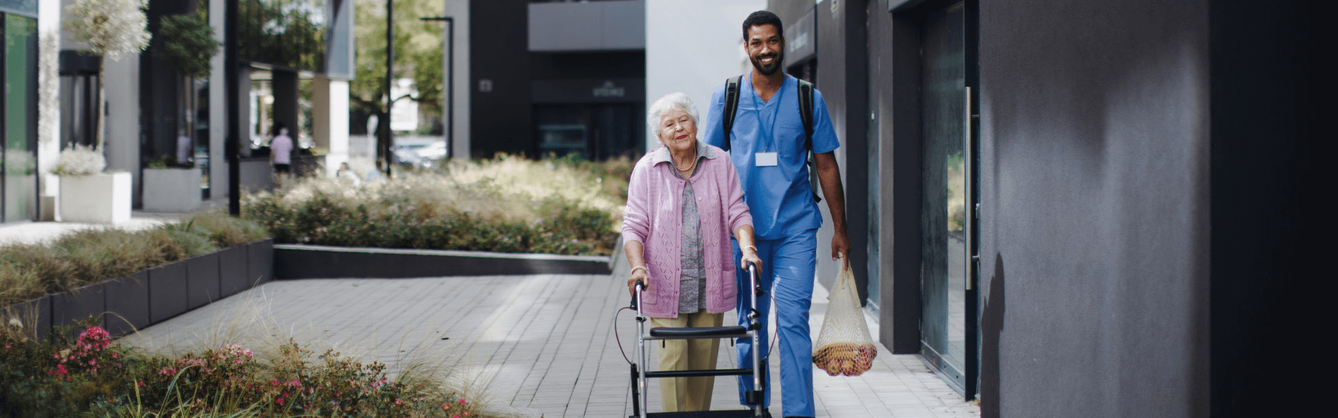 caregiver assisting the elderly carrying the grocery